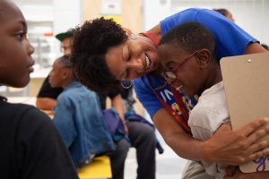 adult teacher hugging a student